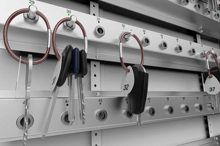 CREONE Schlüsselverwaltung Hängende Schlüssel und Riegel an einer Metalltafel mit Ösen.